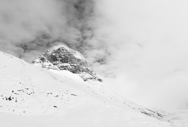 Der Gipfel des Widerstands in den Alpen schaut aus den Wolken heraus. Schwarzweiß Foto