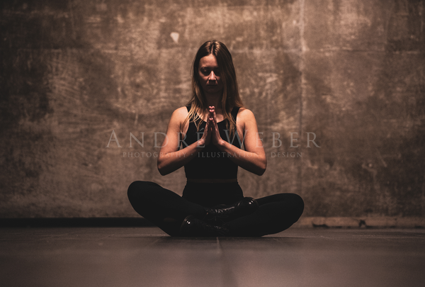 Junge Frau im Yoga Sitz auf dem Boden Post Halle Würzburg