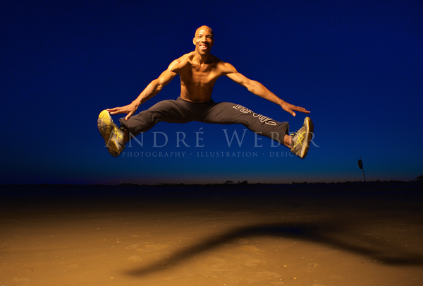 Löse Mann springt am Strand von Portugal in Manta roter. Zumba Instruktor 