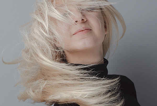 Blondes Mädchen wirft Haare im Studio. Bewerbungsfoto, Portrait Foto