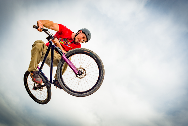 Mountainbike Freestyle er springt über die Kamera in der Luft