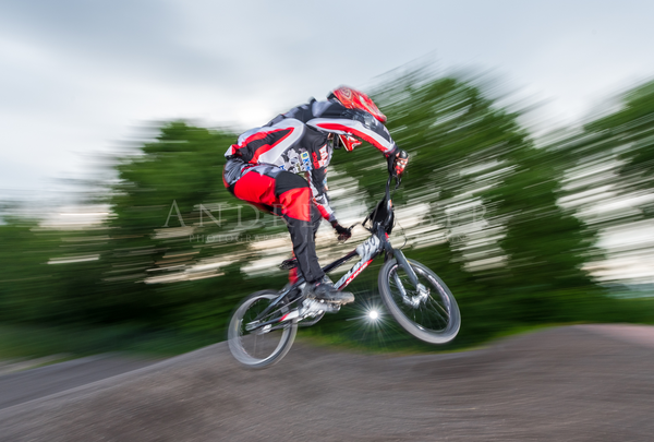 BMX Fahrer springt über einen Hügel