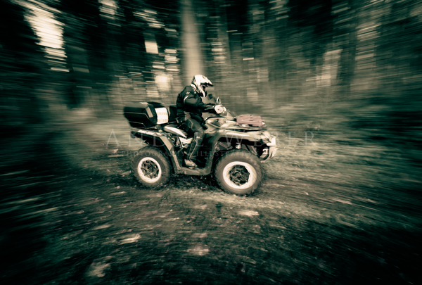 ATV Fahrer Quadtfahrer driftet um die Kurve im Wald